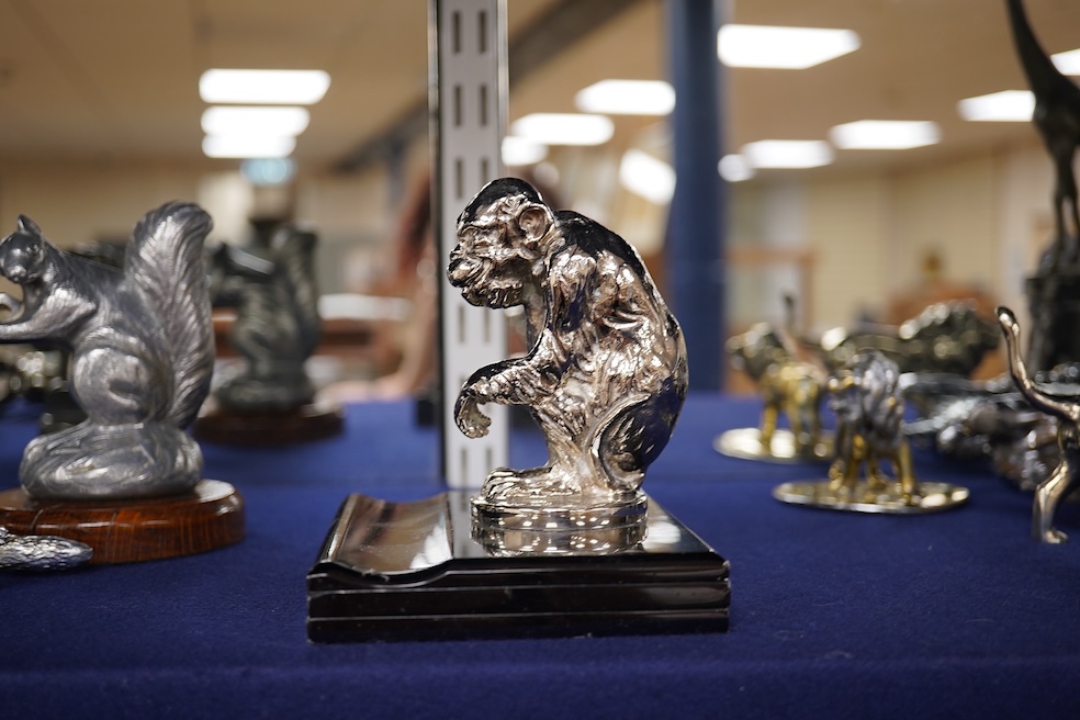 Seven chrome, brass and aluminium car mascots, etc. including an unusual and comical aluminium car mascot in the form of a squirrel holding a nut, together with a standing bear, an Art Deco winged head, a ram, a running